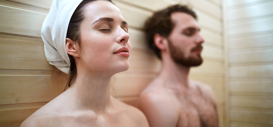 Eine Frau und ein Mann sitzen in der Sauna 